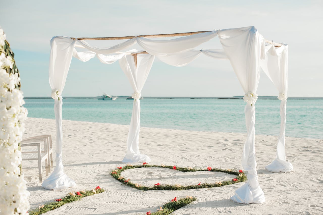 hero-img-01 Beautiful beachfront wedding arch with floral decorations on a sunny day in Maldives.