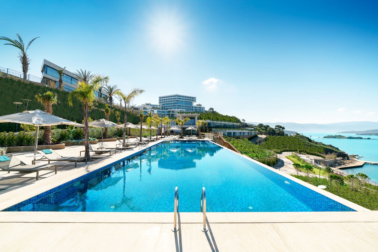 about-01 A luxurious seaside resort in Bodrum, Turkey, featuring a stunning infinity pool under sunny skies.