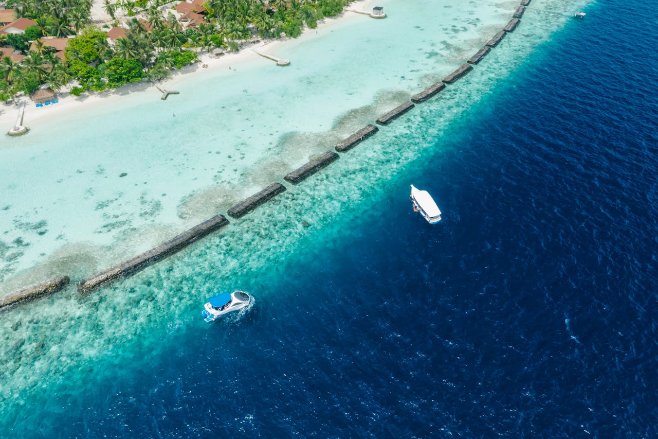 gallery-6 Stunning aerial view of a tropical island with vibrant turquoise water and boats.